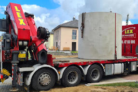 Schwertransporter mit Kran: Anlieferung und Einsetzen einer Betonzisterne