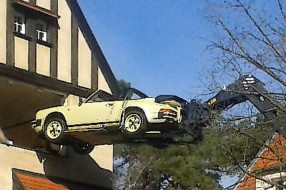 Teleskopstapler hebt Porsche 911 aus dem Fenster